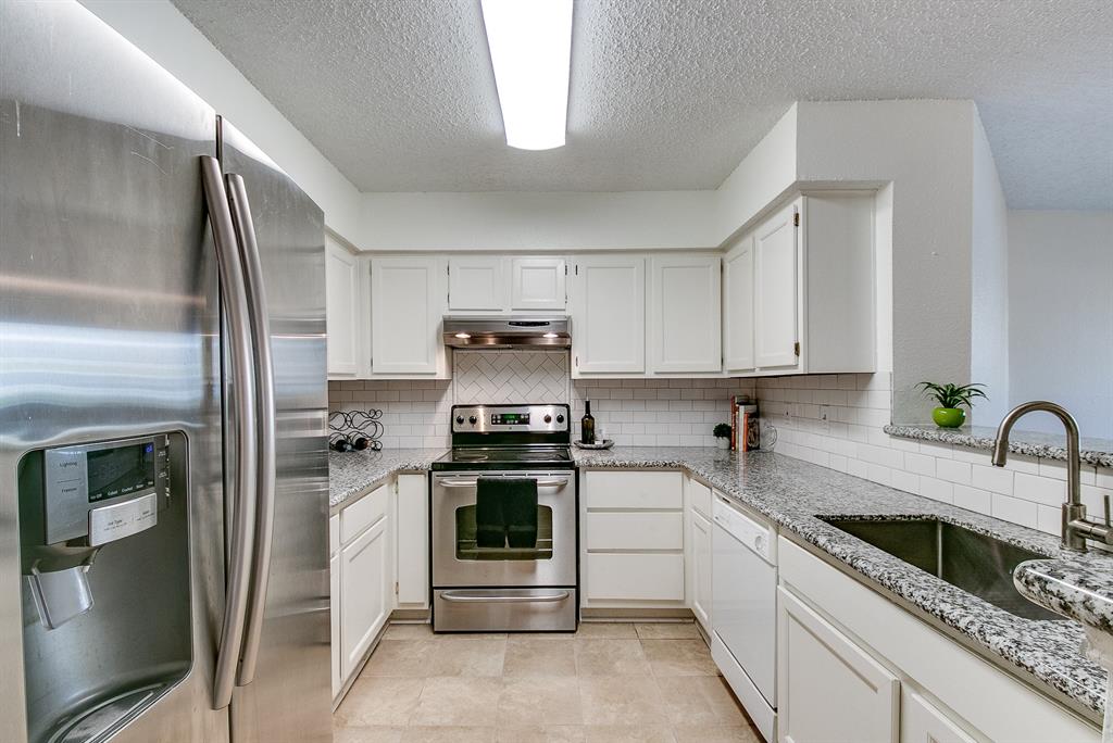 Wonderfully updated kitchen with sleek granite counters including a breakfast bar, subway tile backsplash, SS farmhouse sink, refrigerator with ice and water function and plenty of cabinet space.