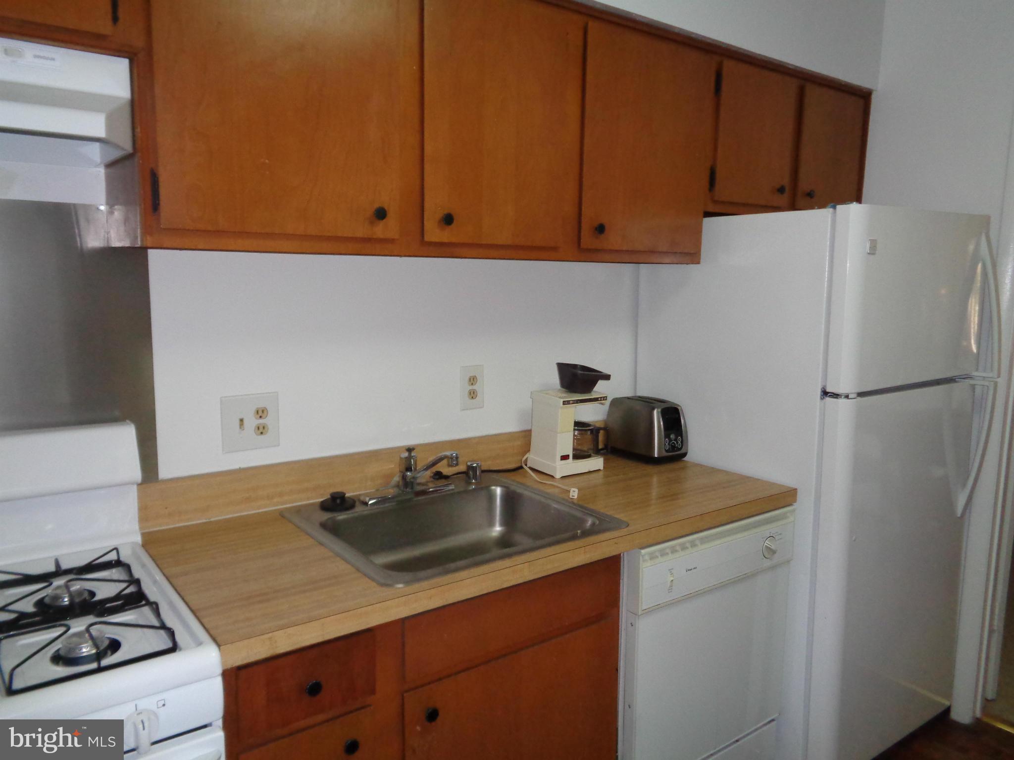 7 Cross Keys Road, Unit 7F Baltimore, MD 21210 - Photo 9 of 27 a kitchen with a sink stove and refrigerator