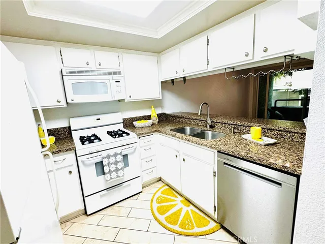a kitchen with stainless steel appliances granite countertop a sink and a stove