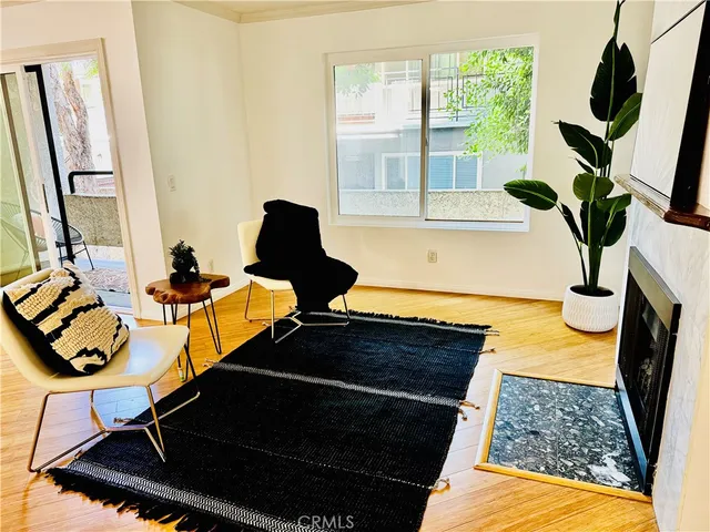 a living room with a fireplace furniture and a large window