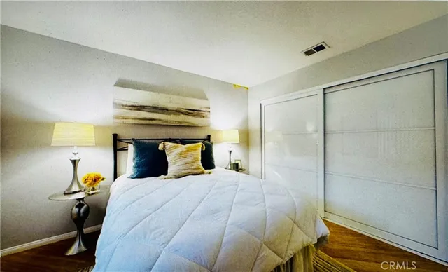 a bedroom with a bed and wooden floor