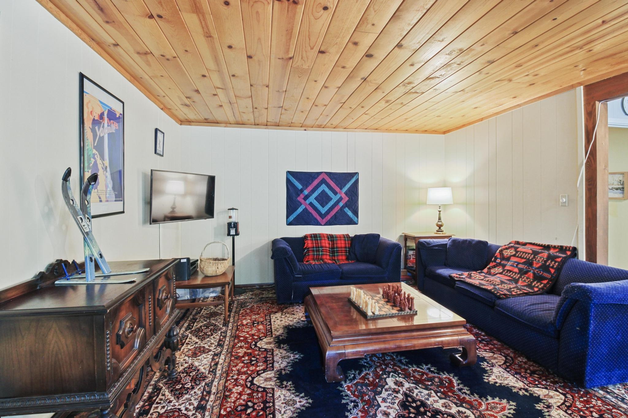 1503 Alpine Meadows Road Alpine Meadows, CA 96146 - Photo 6 of 28 a living room with furniture a rug and a wall painting