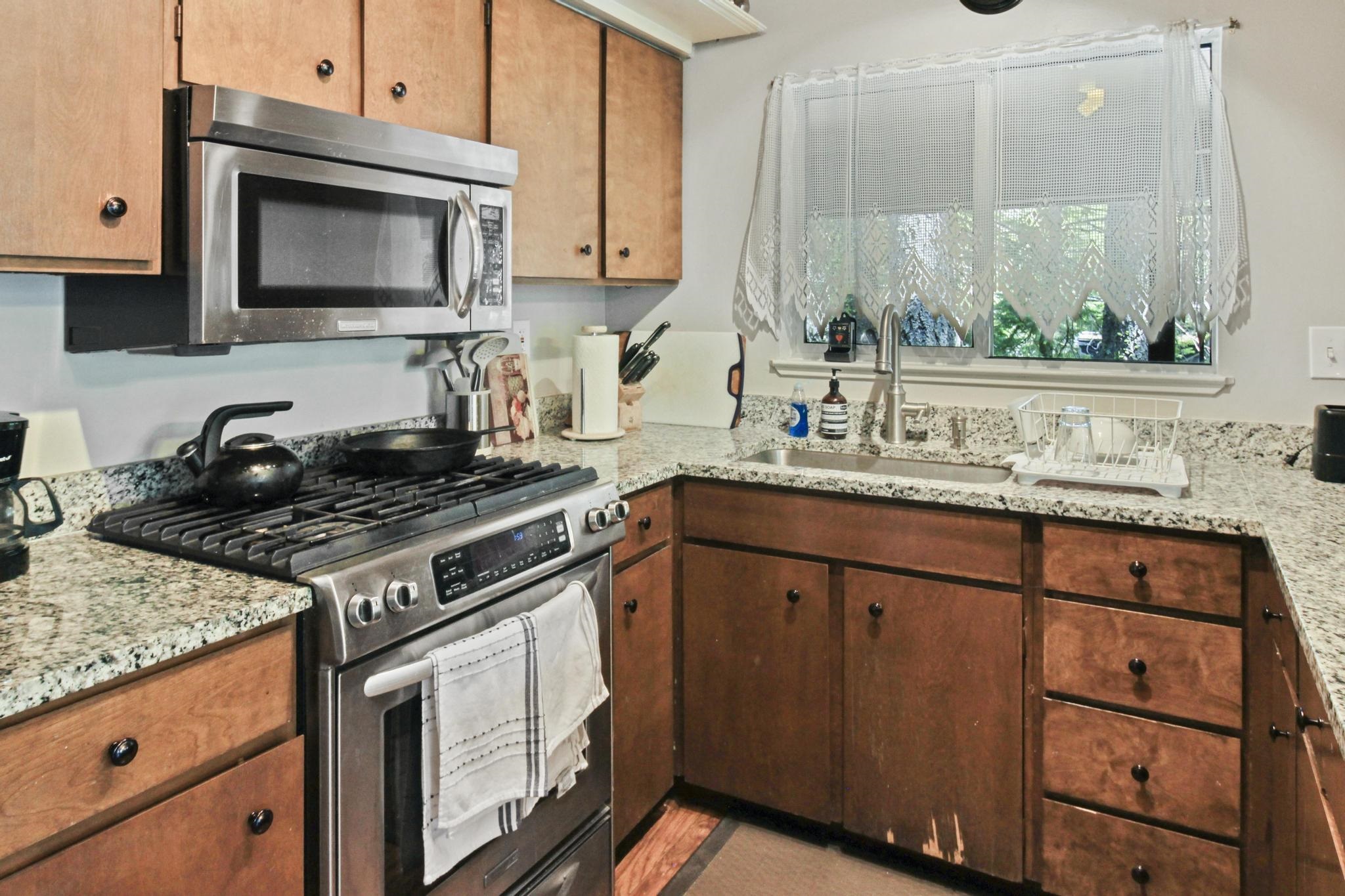 1503 Alpine Meadows Road Alpine Meadows, CA 96146 - Photo 9 of 28 a kitchen with stainless steel appliances granite countertop a stove a sink and a microwave