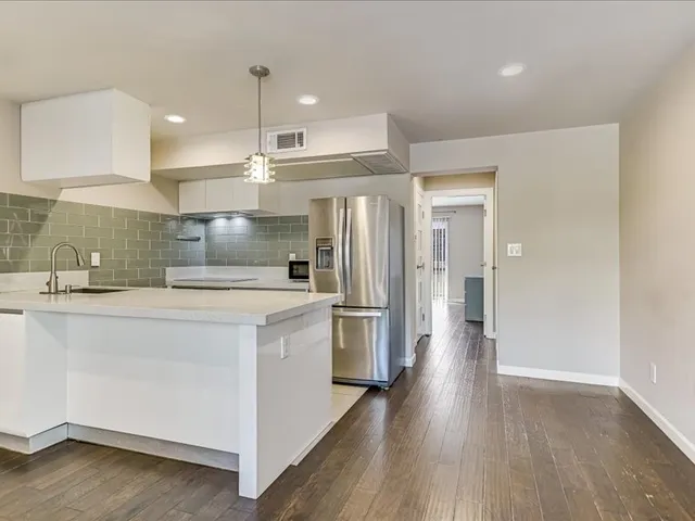 a kitchen with stainless steel appliances a refrigerator and a stove top oven