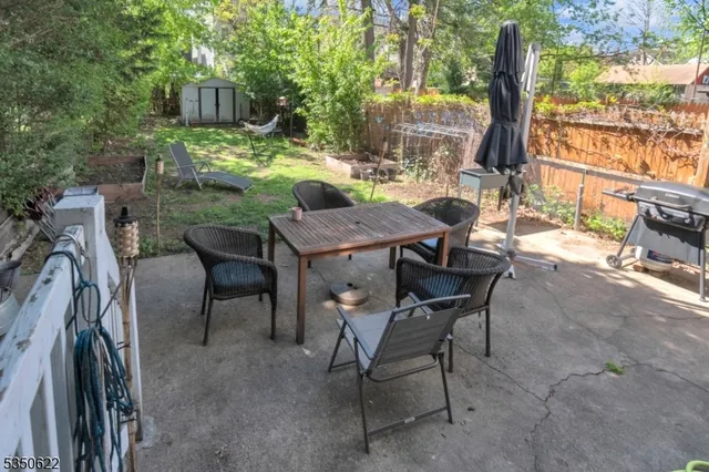 a view of backyard with outdoor seating and wooden fence