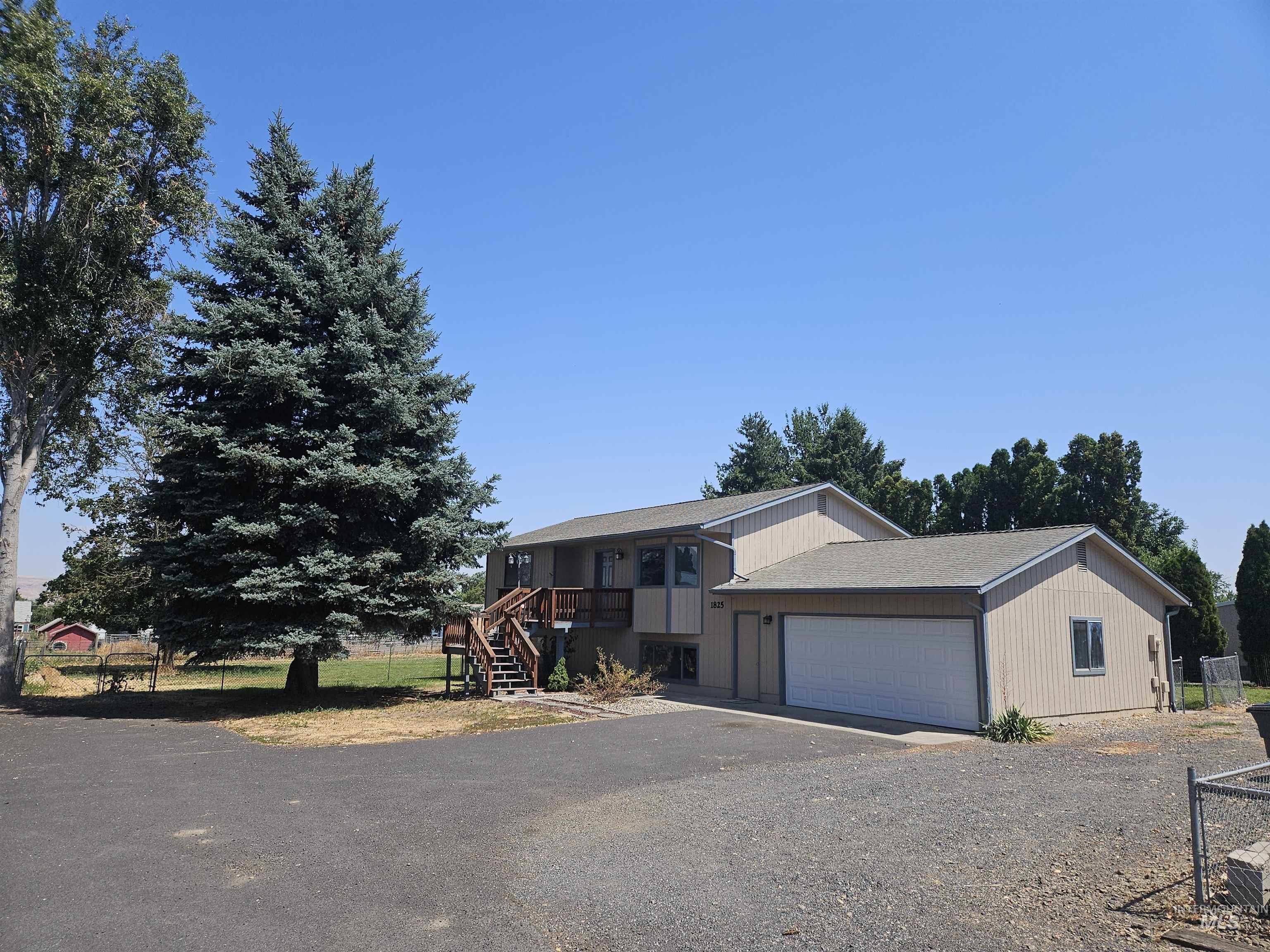 1825 Cedar Avenue Lewiston, ID 83501 - Photo 30 of 39 View of front facade with asphalt driveway, a garage, a shingled roof, and stairway