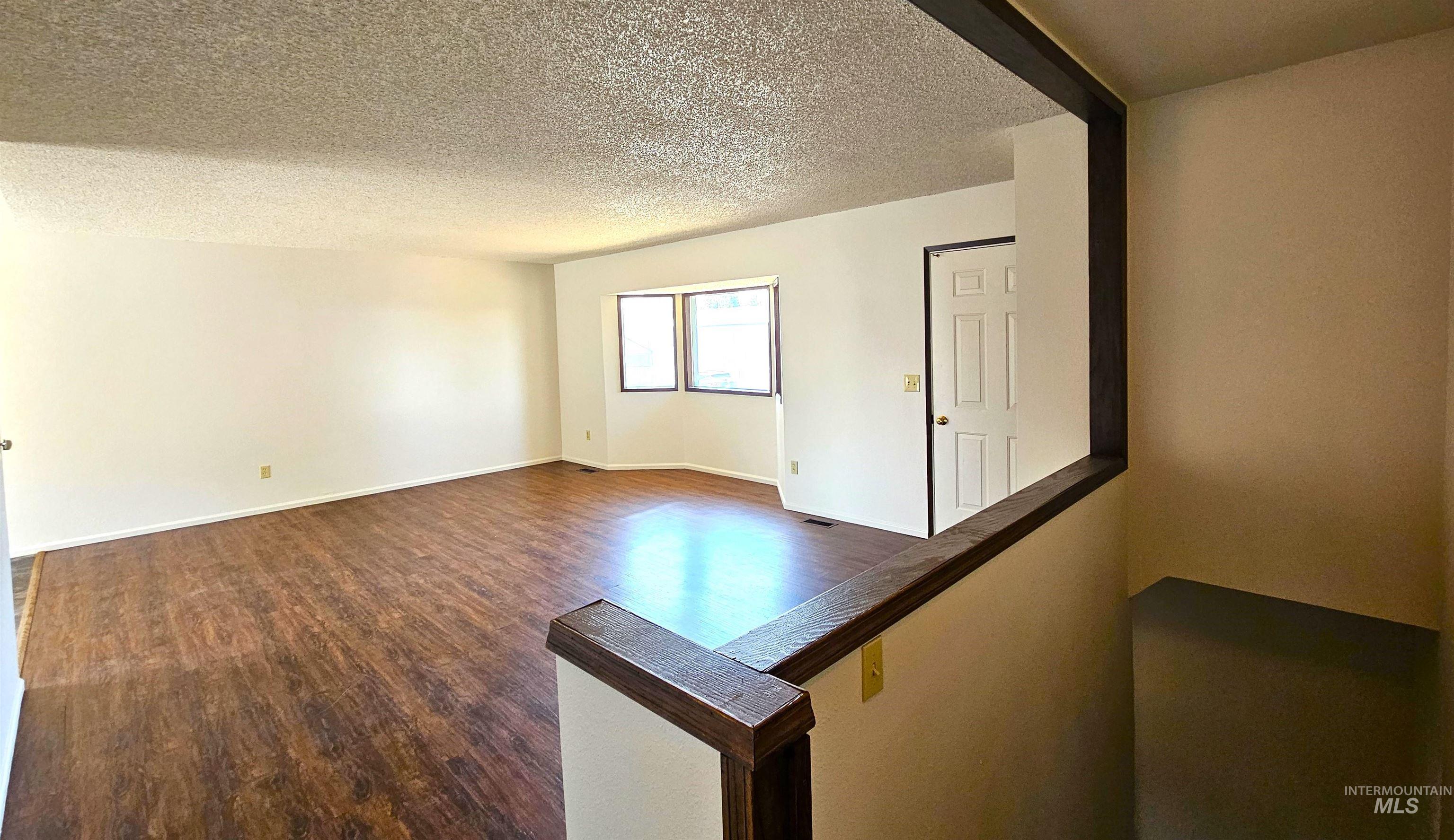 1825 Cedar Avenue Lewiston, ID 83501 - Photo 5 of 39 Unfurnished room with dark wood-style floors and a textured ceiling