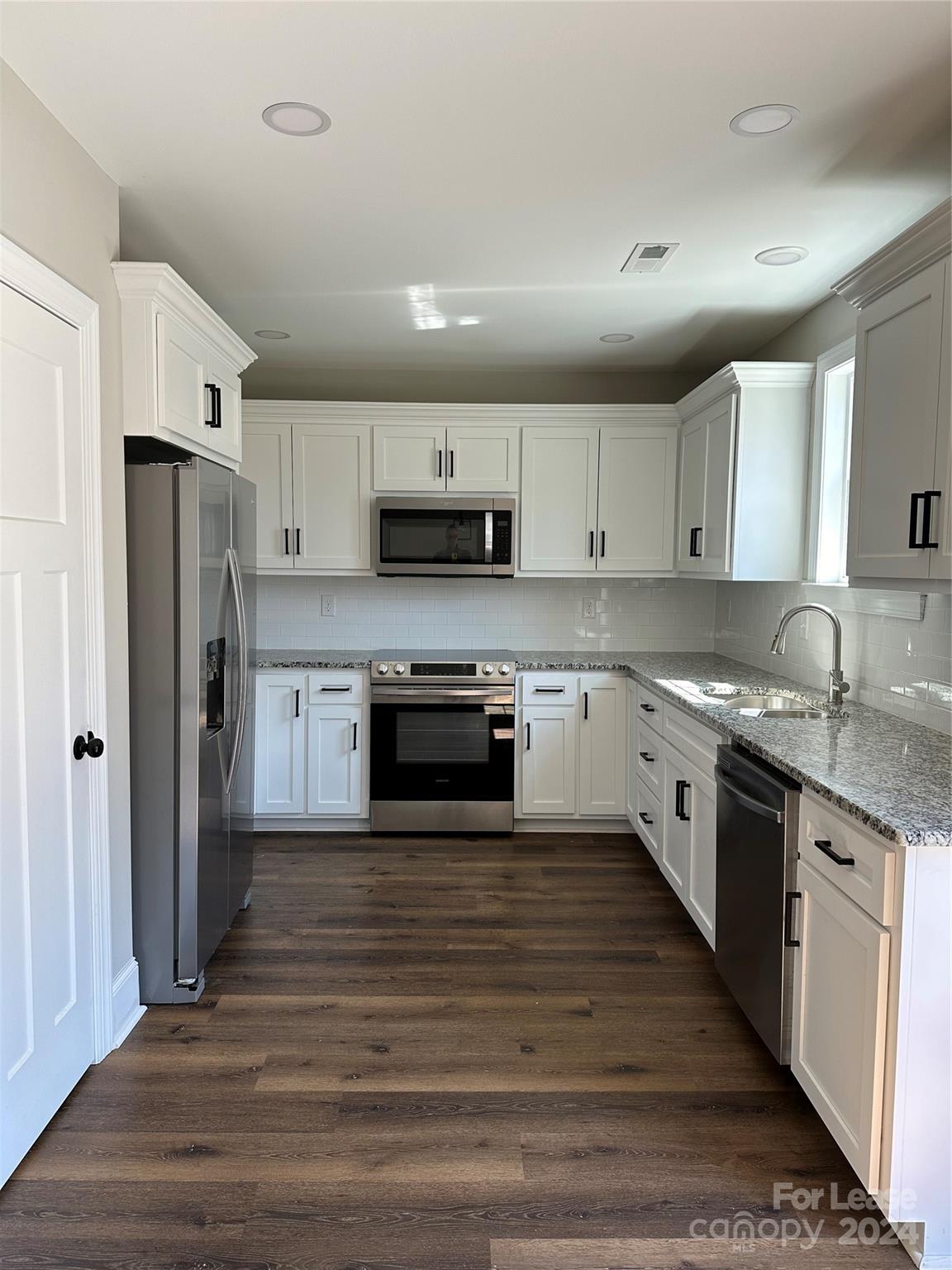 5507 Bucks Garage Road, Unit A Maiden, NC 28650 - Photo 5 of 17 a large kitchen with cabinets stainless steel appliances and a window