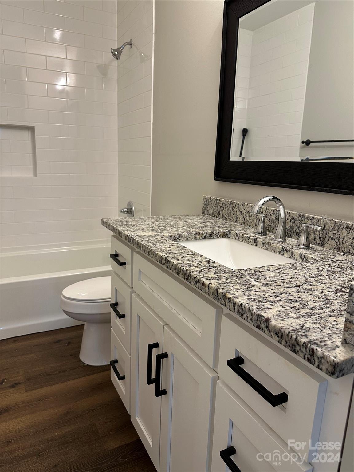 5507 Bucks Garage Road, Unit A Maiden, NC 28650 - Photo 10 of 17 a bathroom with a granite countertop sink a toilet and a mirror