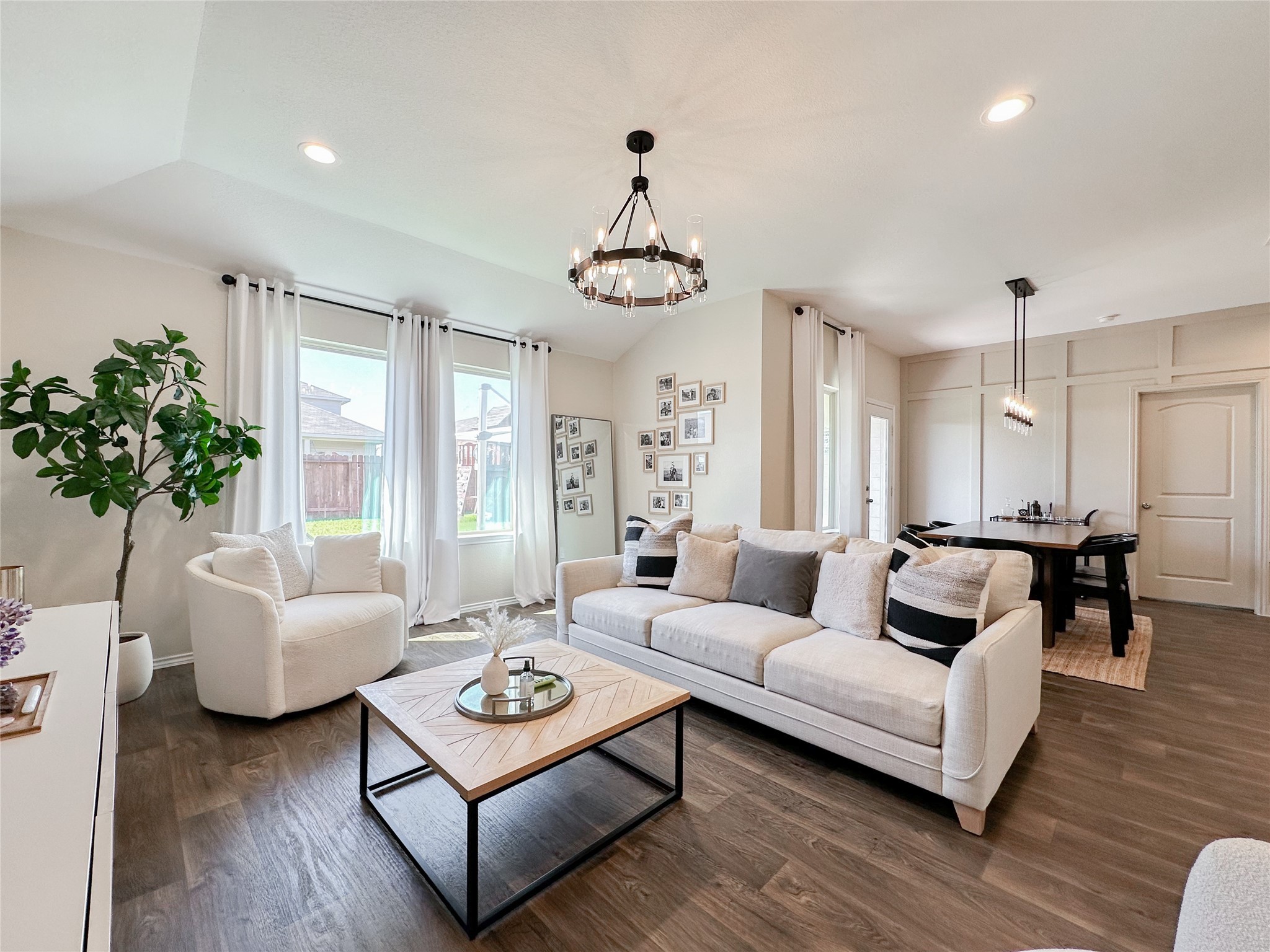 a living room with furniture potted plant and a chandelier