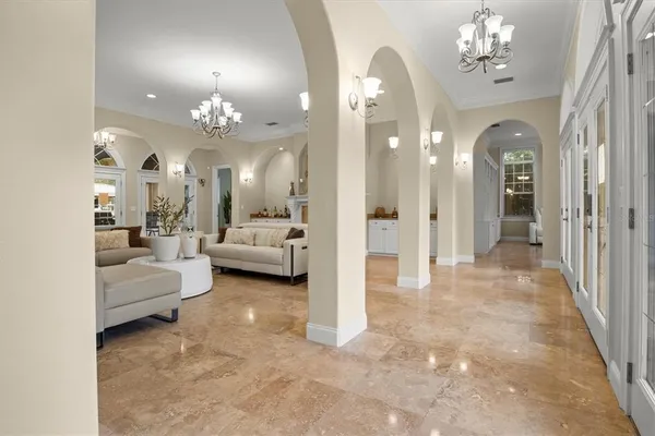a view of a dining room with furniture a chandelier and wooden floor