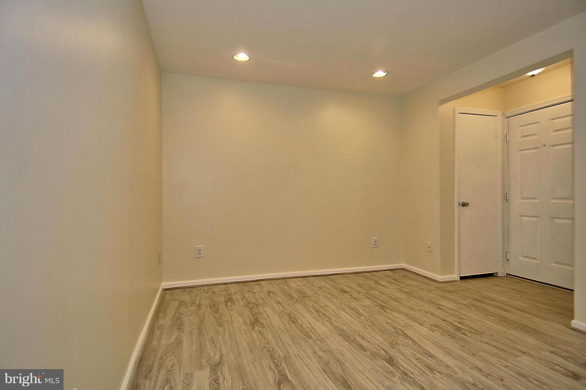 10706 Kings Riding Way, Unit T218 Rockville, MD 20852 - Photo 4 of 17 a view of an empty room with wooden floor and a window