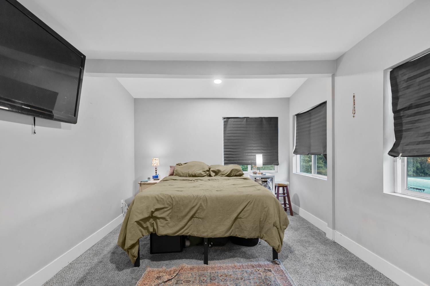 17721 Ridge Road Pine Grove, CA 95665 - Photo 10 of 21 a bedroom with a bed a flat screen tv and windows