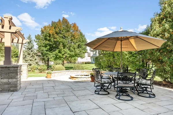 a view of a patio with table and chairs under an umbrella