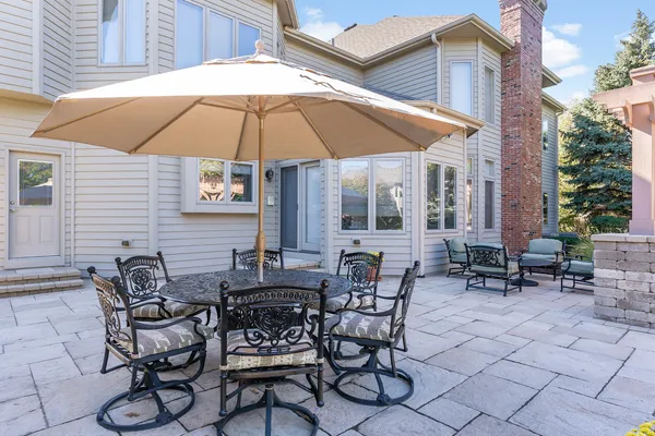 a view of the patio with furniture and table under an umbrella