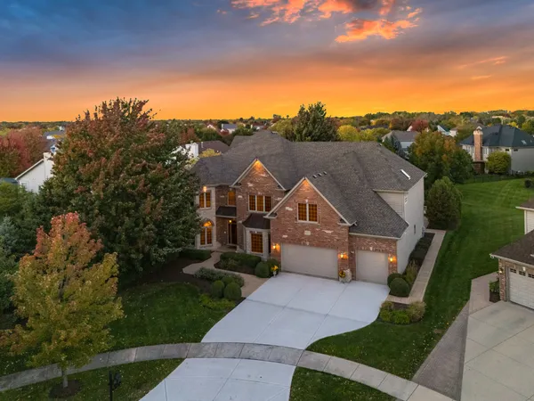 a front view of a house with a yard and mountain view in back