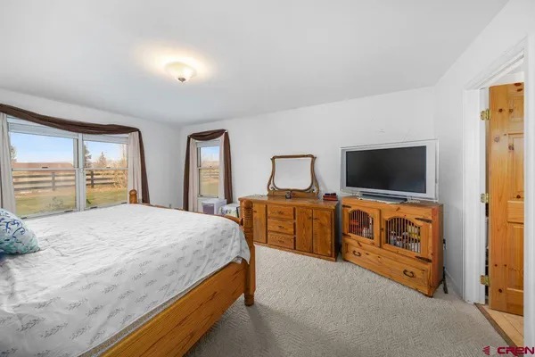 a bedroom with a bed and a flat screen tv