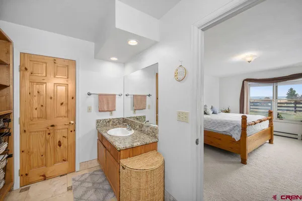 a spacious bathroom with a granite countertop sink and a mirror
