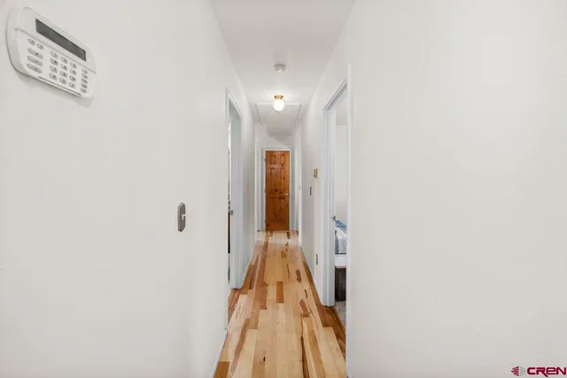 a view of a hallway with wooden floor and staircase