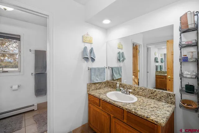 a bathroom with a granite countertop sink and a mirror