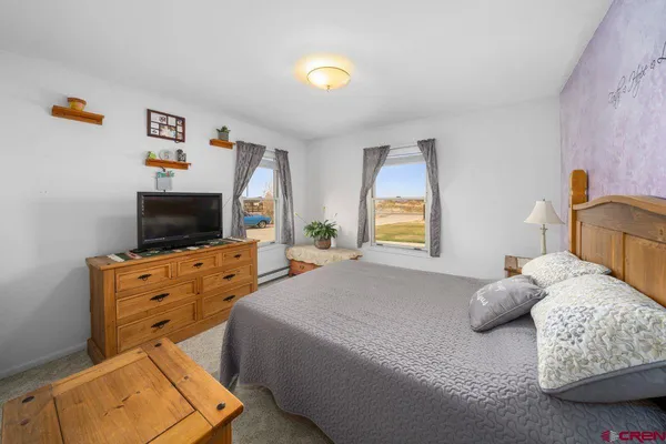 a bedroom with furniture and a flat screen tv