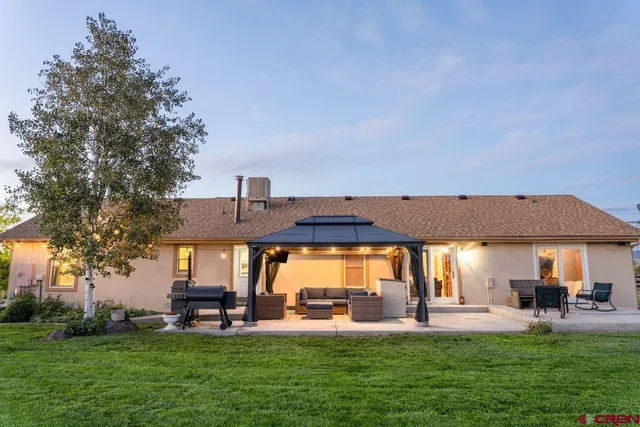 a front view of a house with garden and trees