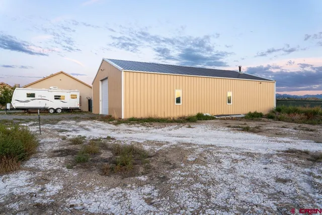 a view of a house with backyard and trees