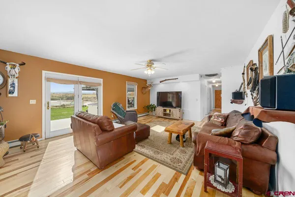 a living room with furniture a flat screen tv and a large window