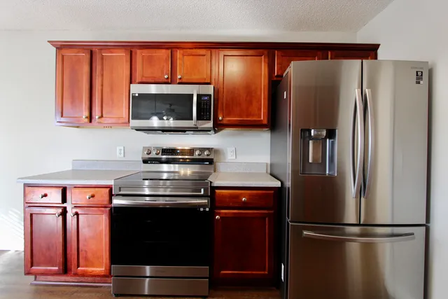 a kitchen with stainless steel appliances granite countertop a refrigerator stove and microwave