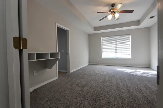 a view of empty room with windows and ceiling fan