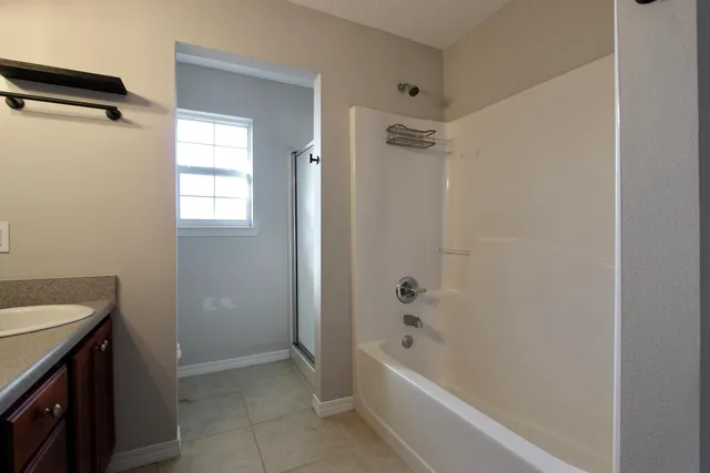 a bathroom with a tub a sink and a shower