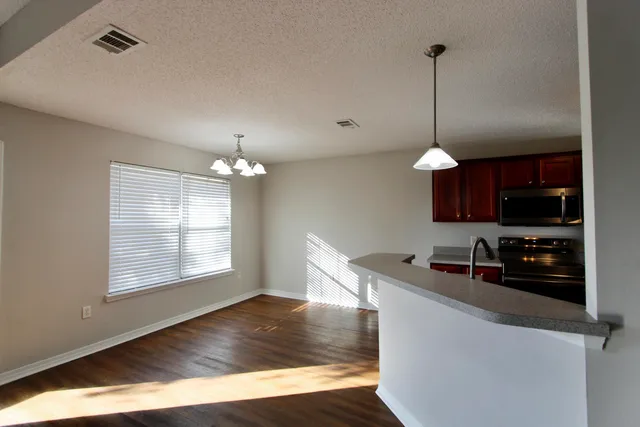 a kitchen that has a microwave a sink and a stove in it