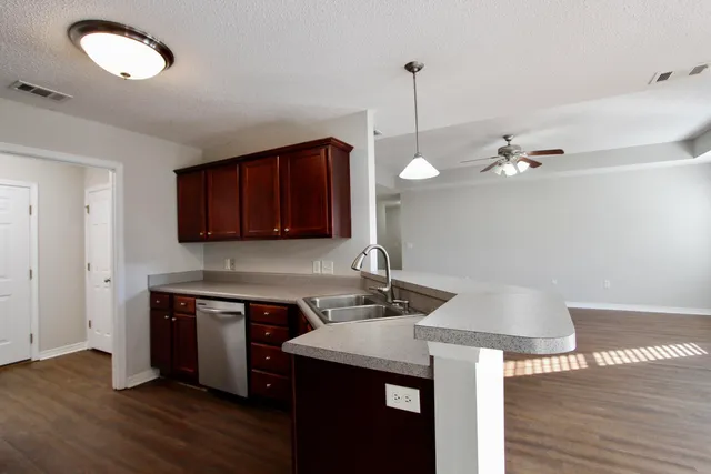a kitchen with a sink cabinets and wooden floor