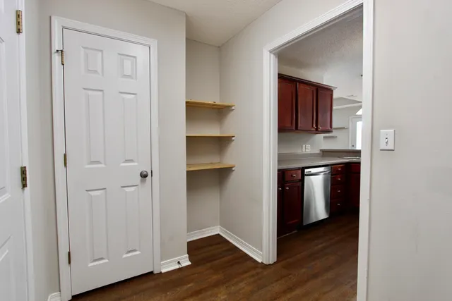 a view of kitchen with wooden floor and cabinets