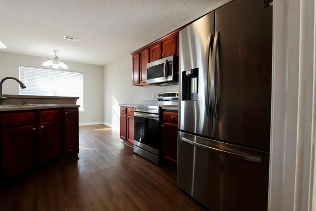 a kitchen with stainless steel appliances granite countertop a refrigerator and a sink
