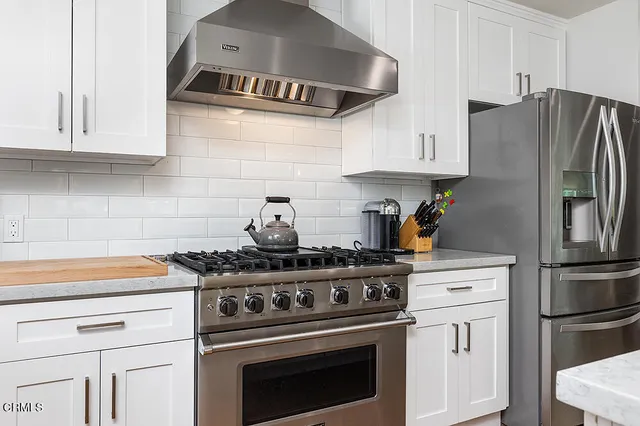 a kitchen with stainless steel appliances granite countertop a stove and a refrigerator