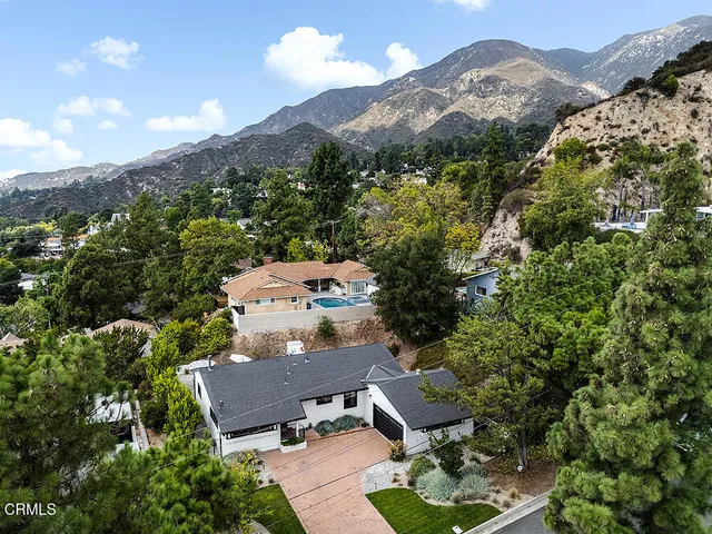 an aerial view of a house with a mountain