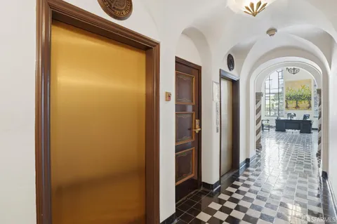 a view of a hallway with wooden floor and a dining room with chandelier