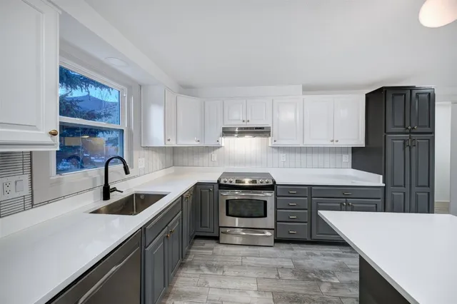 a kitchen with stainless steel appliances granite countertop a sink stove and refrigerator