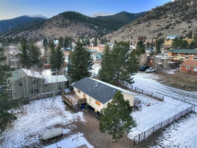 an aerial view of a house with a yard and mountain