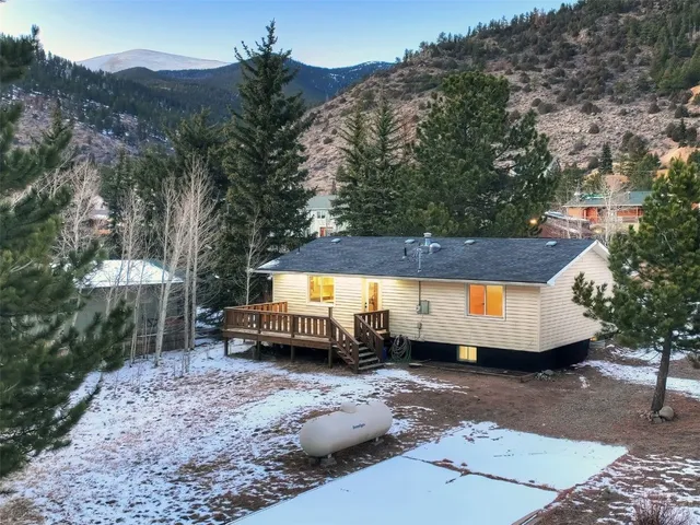 a house view with a sitting space fire pit and outdoor space