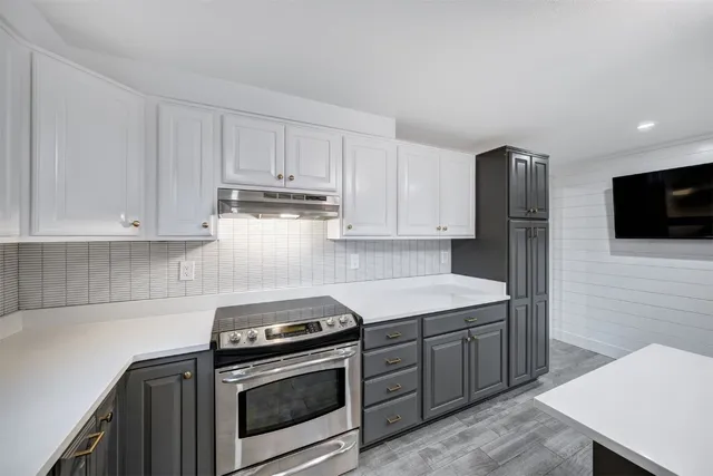 a kitchen with stainless steel appliances granite countertop a stove a refrigerator and a microwave