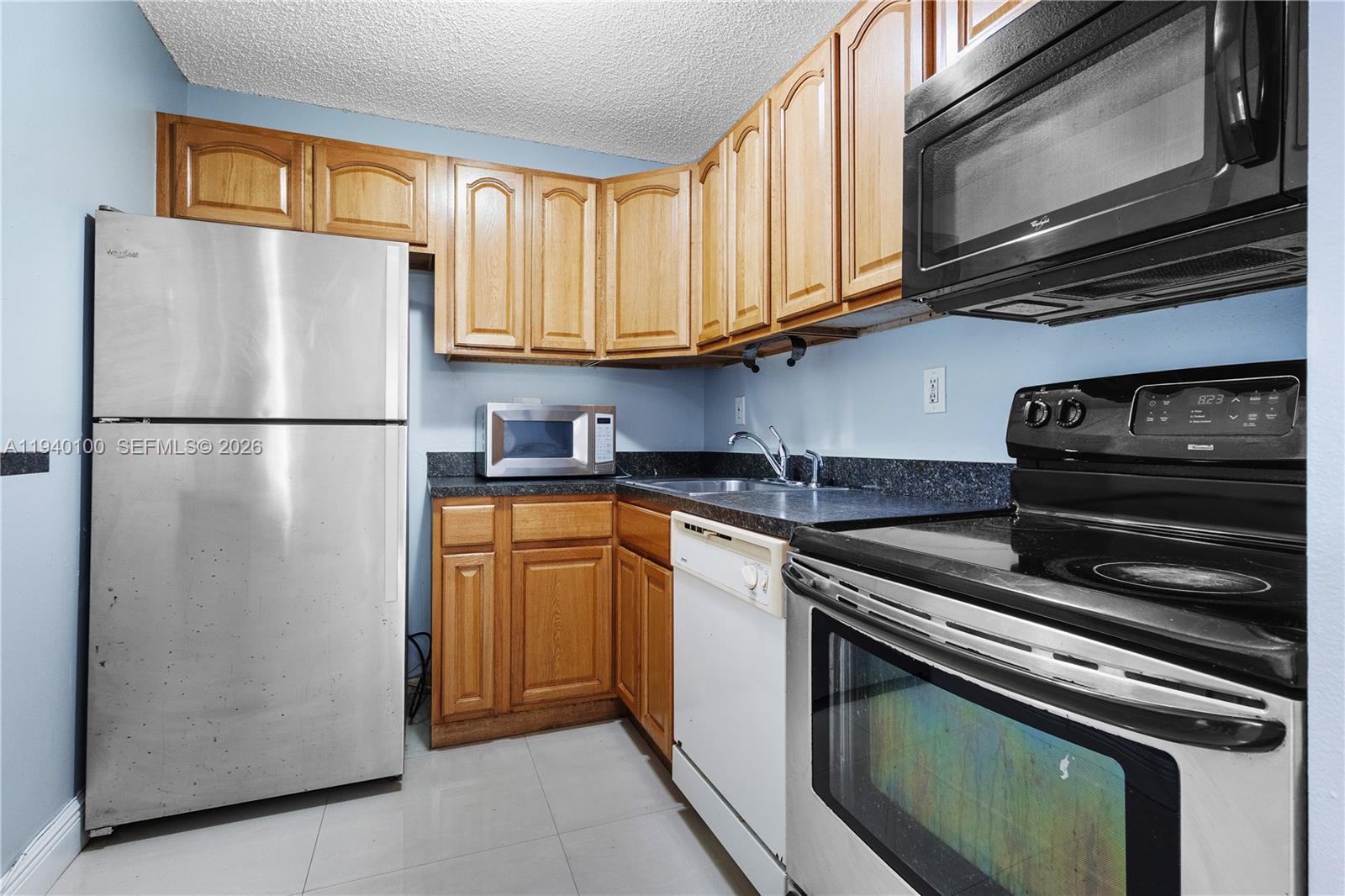 15520 Southwest 80th Street, Unit B301 Miami, FL 33193 - Photo 15 of 26 a white refrigerator freezer sitting in a kitchen