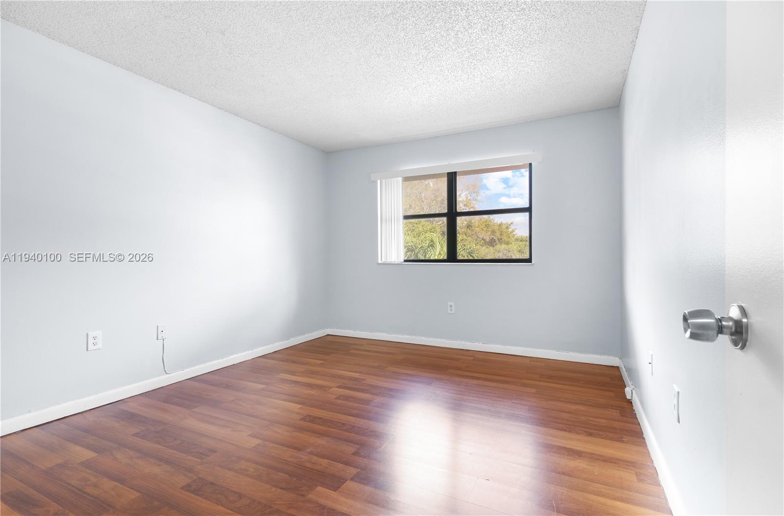 15520 Southwest 80th Street, Unit B301 Miami, FL 33193 - Photo 16 of 26 an empty room with wooden floor and windows
