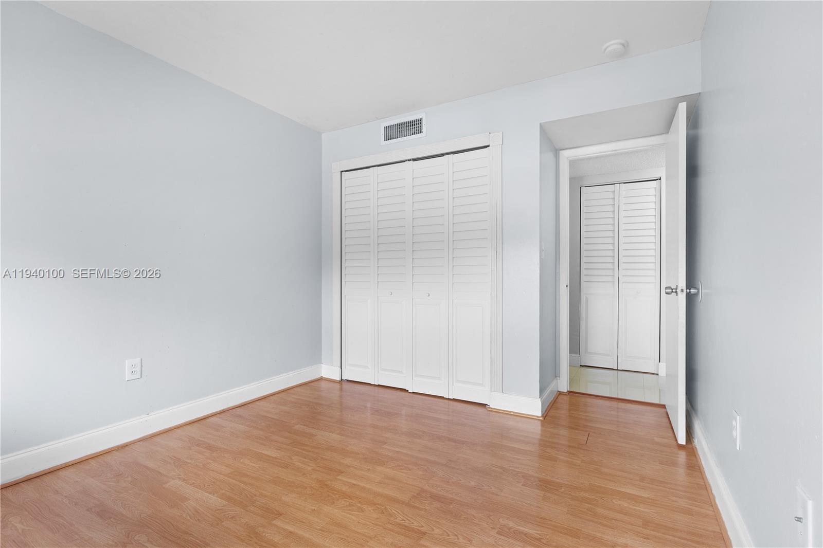 15520 Southwest 80th Street, Unit B301 Miami, FL 33193 - Photo 19 of 26 a view of an empty room with wooden floor and closet
