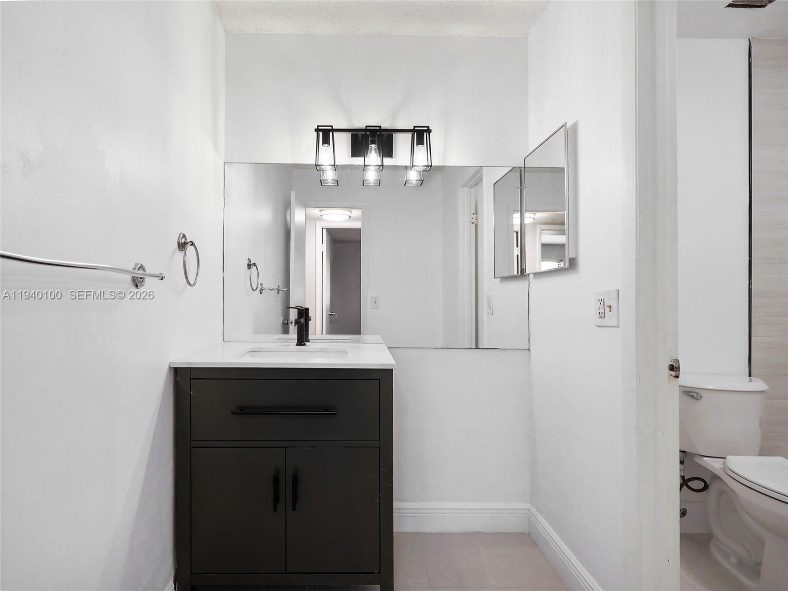 15520 Southwest 80th Street, Unit B301 Miami, FL 33193 - Photo 20 of 26 a bathroom with a sink and a mirror