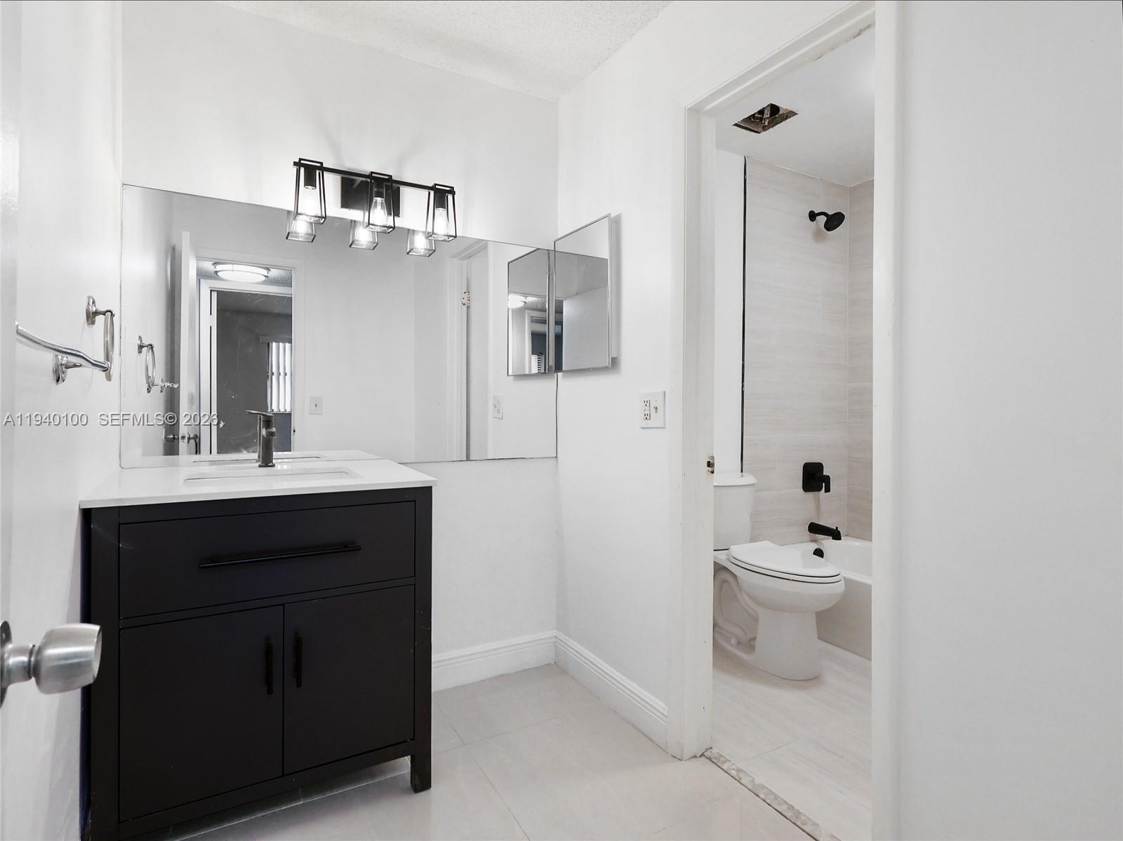 15520 Southwest 80th Street, Unit B301 Miami, FL 33193 - Photo 4 of 26 a bathroom with a toilet sink shower and mirror