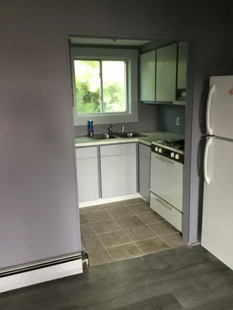 a kitchen with granite countertop a stove a sink and a refrigerator