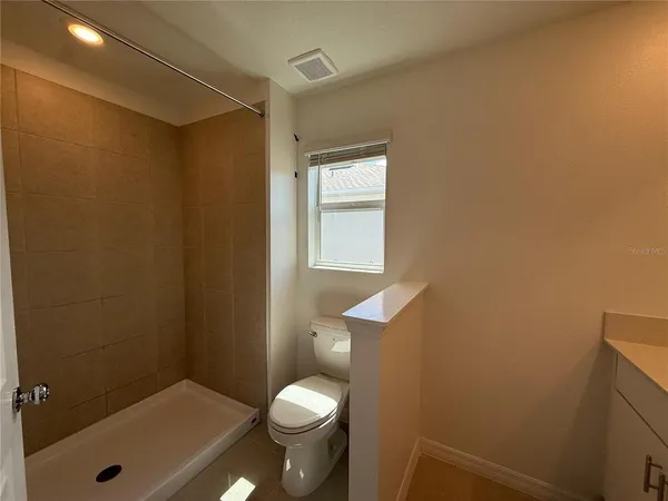 a bathroom with a granite countertop sink toilet and shower