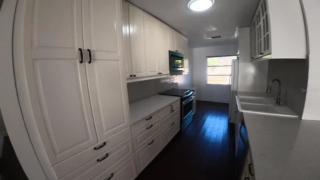 a kitchen with cabinets and a wooden floor